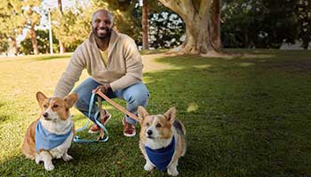 Outdoor scene showing a person with two dogs on leashes