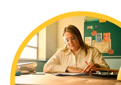 Person writing in a notebook at a desk
